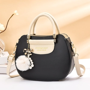 Contrast color rhombic pattern handbag with pearl and bow charms in elegant studio setting