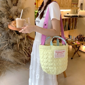 Détail du sac cabas jaune à surpiqûres cœurs avec poignées bleues et bandoulière violette