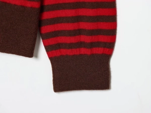 Détail des poignets côtelés sur le pull en maille rayé rouge et marron foncé doux