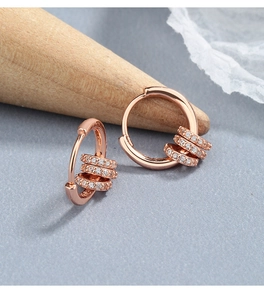 Detailed close-up of rose gold silver hoop earrings with three moving micro-pave zircon rings