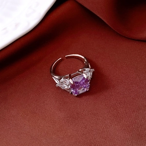 Detailed macro view of vintage silver ring with purple zircon stone on silk fabric