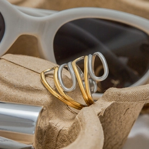 Macro view of multi-layer intertwined gold and silver stainless steel rings on paper tray
