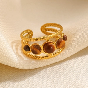 Adjustable golden twisted cable ring with five brown tiger eye stones on beige silk