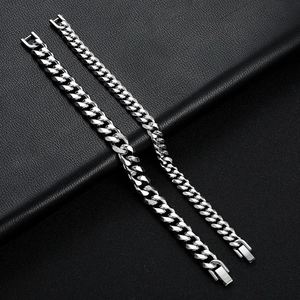 Detail of silver titanium steel Cuban chain bracelets with fold-over clasps on leather