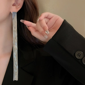 Close-up of silver tassel earrings worn by model for an elegant high-fashion jewelry look