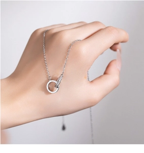 Close-up of interlocking silver double ring necklace with micro-pave cubic zirconia stones