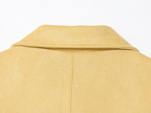 Detail of yellow faux suede jacket featuring a lapel collar and clean center back stitching