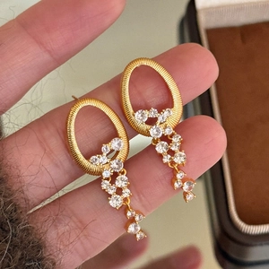 Élégantes boucles d'oreilles dorées à glands avec boucles ovales et cristaux scintillants