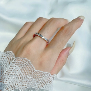 Macro shot of S925 silver wedding ring with zircon pave setting on white silk background