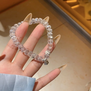 Détail d'un bracelet en perles de cristal avec pendentif lotus argenté en main