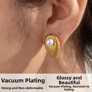 Macro side view of vintage gold teardrop earrings with a white pearl and radial texture
