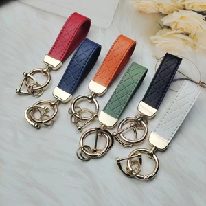 Zinc alloy car keychain with braided leather straps in six colors on plush background