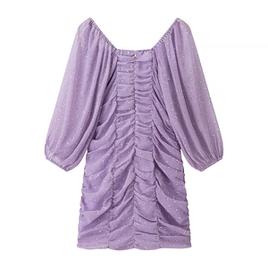 Dettaglio macro del design arricciato e del tessuto in chiffon su questo abito viola