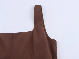 Gros plan d'une robe midi marron foncé avec larges bretelles et détails de coutures visibles
