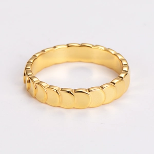 Macro detail of golden mermaid scale texture on polished stainless steel ring band