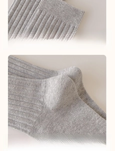 Detail of gray ribbed cotton socks showing elastic cuffs and reinforced heel durability