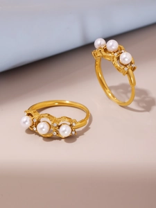 Macro detail of gold adjustable rings featuring three white pearls and micro-pave zircons