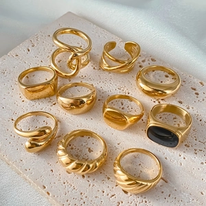 Assortiment gouden minimalistische ringen met diverse texturen op een stenen plateau