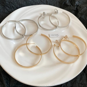 Macro view of gold and silver hoop earrings in stud and clip-on styles for women