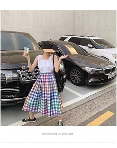 Detail of white sleeveless top and vibrant colorful plaid midi skirt set for women