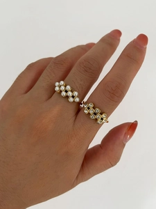Detail of 18k gold plated open rings with pearls and zircons worn on female fingers