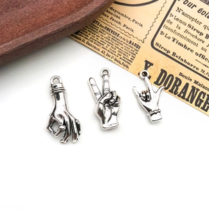 Close-up of three antique silver hand gesture charms for DIY jewelry making