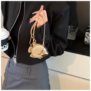 Close-up of golden fish-shaped metal evening bag with detailed scale texture and chain