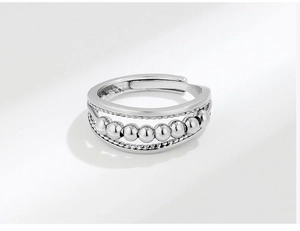 Detail of silver stainless steel anxiety ring with rotating beads and chain texture