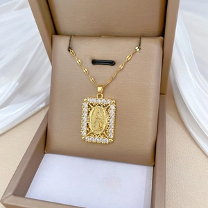 Luxurious gold portrait pendant necklace with crystal border on beige jewelry box