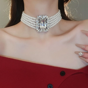 Detail of multi-layer pearl choker with a large rectangular crystal pendant on model
