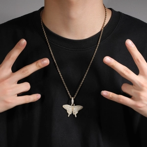 Close-up of golden rope chain and hip hop butterfly pendant with diamonds on model