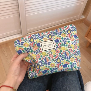 Floral cotton cosmetic bag with Time to Party label held in hand for daily use