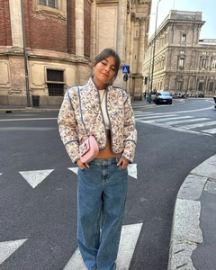 Streetstyle-look van bloemen doorgestikte jas gecombineerd met jeans en roze tasje