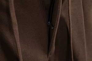 Detailed macro view of high-quality metal zipper on brown twill trousers for men