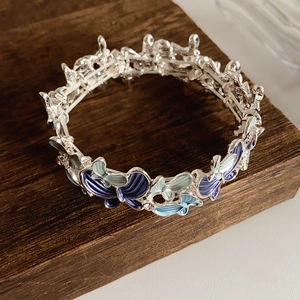 Macro shot of silver-tone metal butterfly bracelet with blue gradient enamel and small crystals