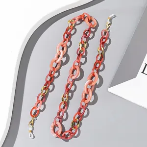 Detail of colorful acrylic eyeglass chain with tortoiseshell texture and golden metal links