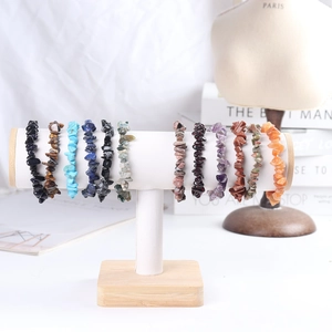 Detail of natural crystal stone bracelets displayed on a white T-bar jewelry stand