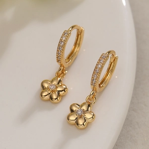 Minimalist gold plated flower hoop earrings with sparkling cubic zirconia on white plate