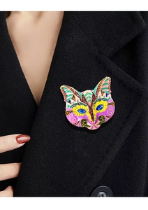 Detail of vintage cat mask brooch with colorful enamel and rhinestones on black coat