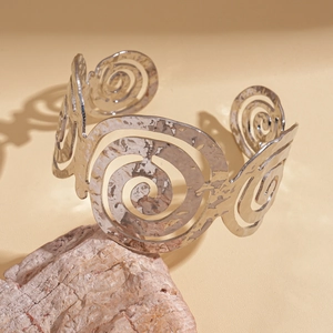 Détail du bracelet manchette argenté martelé avec motif spirale creux sur support