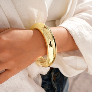Close-up of a chunky polished gold geometric bangle on a wrist for a modern look