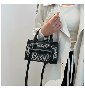 Detalle de bolso con estampado de leopardo, bolsillo con cremallera y correa de PU