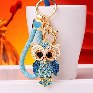 Detailed close-up of crystal owl keychain with blue rhinestones and braided strap