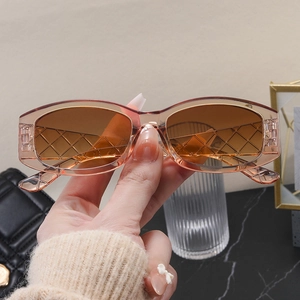 Detail of amber rectangle sunglasses featuring textured diamond lattice temples