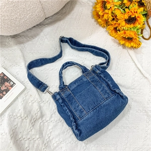 Detailed view of blue denim tote bag with adjustable strap and visible stitching details