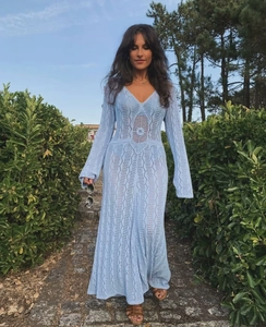 Detailliertes blaues Strickmaxikleid mit V-Ausschnitt und Lochmuster im Freien