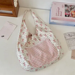 Détail d'un sac cabas floral avec poche en dentelle à carreaux rose et nœuds