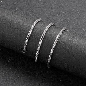 Detailed view of silver wheat chain necklace with lobster clasp on dark display