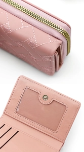 Macro detail of pink PU leather wallet showing heart embroidery and multiple card slots