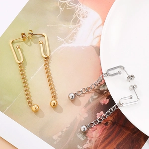 Detail of minimalist long tassel chain earrings with metal beads in gold and silver finish